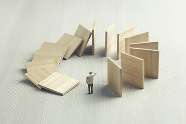 A man standing between falling dominoes | SV Partners