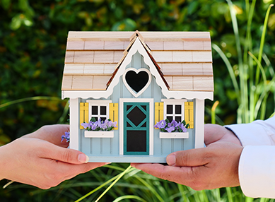 Man & woman holding a small dolls house | SV Partners