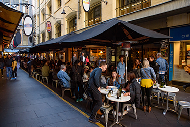 People at outdoor restaurant seating in a laneway | SV Partners