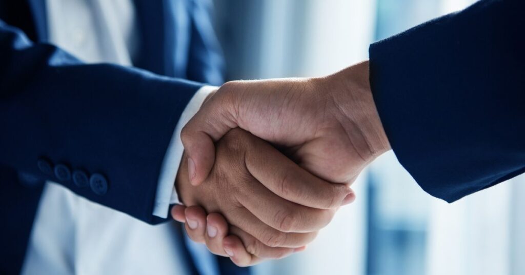 Two men shaking hands after a debt agreement